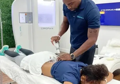 A man is using an electric device to treat a woman 's back.