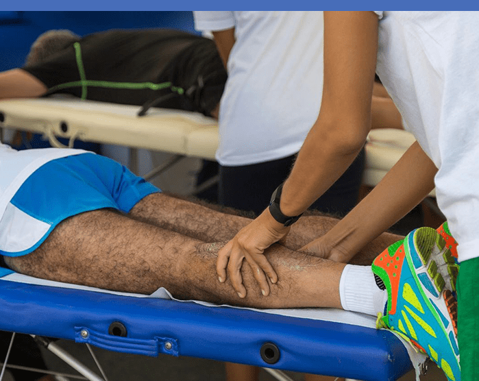 A person is getting his leg waxed by an attendant.